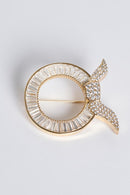 text -- gold brooch