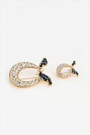 text -- brooch gold black blue