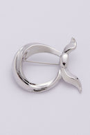 text -- silver brooch