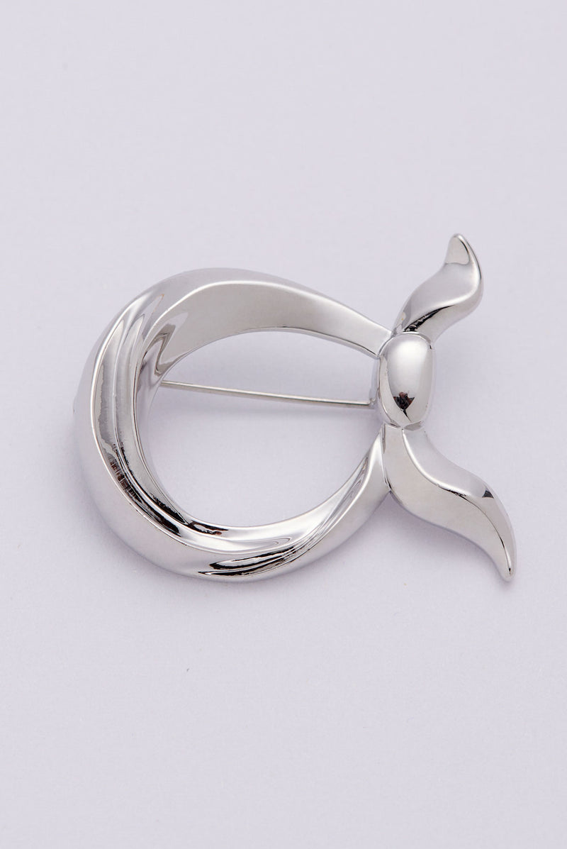 text -- silver brooch